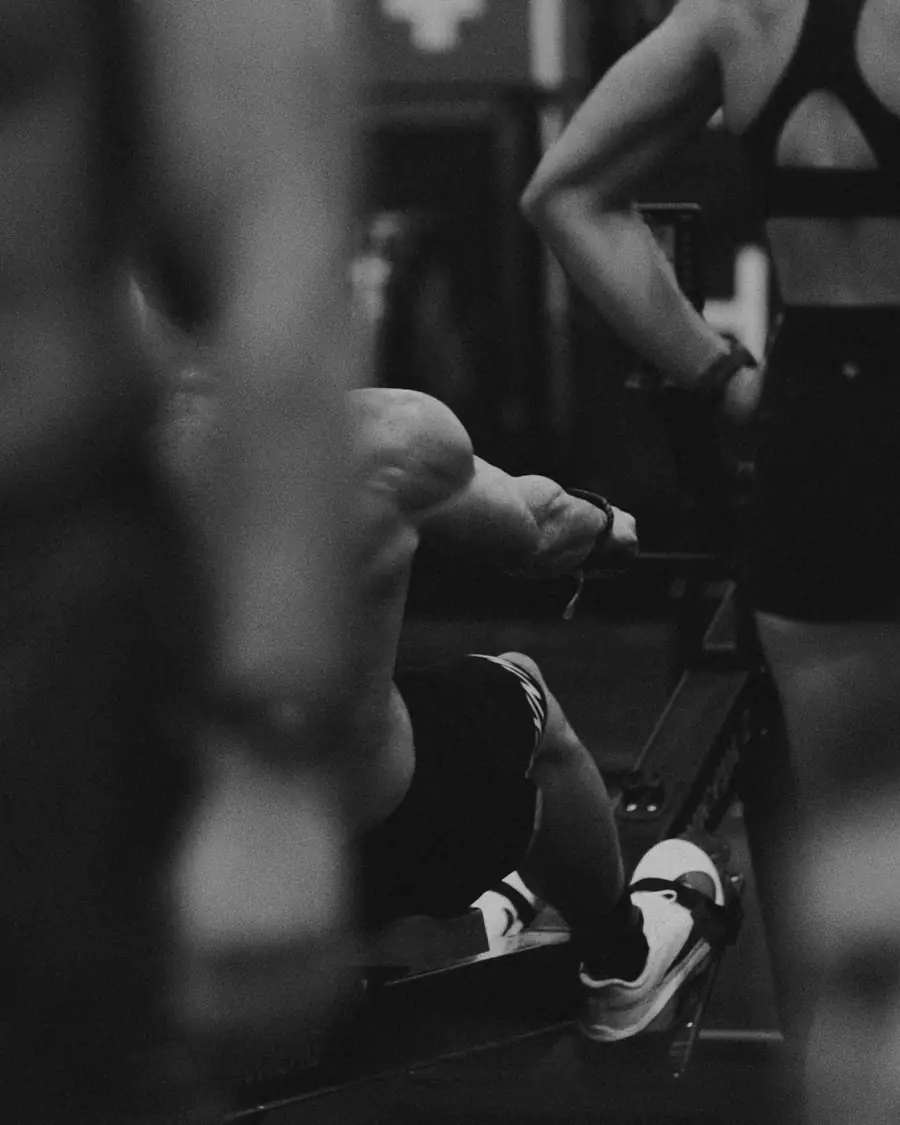 Rower at the catch, seen through the rack